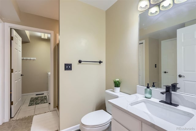 bathroom featuring toilet, tile patterned floors, vanity, and baseboards