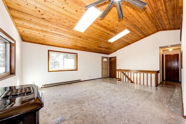 empty room featuring ceiling fan, a baseboard heating unit, lofted ceiling with skylight, and wooden ceiling