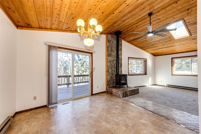 unfurnished living room featuring a baseboard radiator, a wood stove, vaulted ceiling with skylight, and wood ceiling