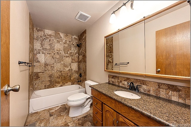 full bathroom featuring vanity, tasteful backsplash, a textured ceiling, tiled shower / bath, and toilet