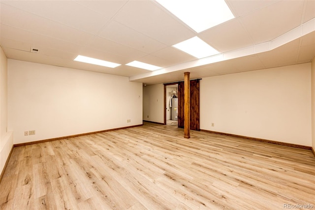 basement featuring water heater and light wood-type flooring