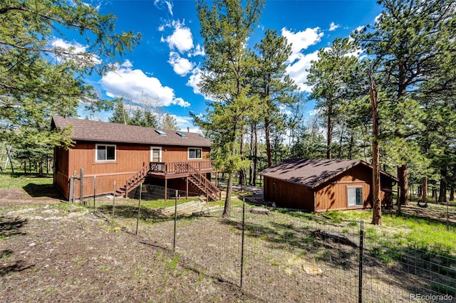224 Yellow Pine Dr, Bailey, CO 80421 - back of house featuring stairs, a wooden deck, an outbuilding, and roof with shingles