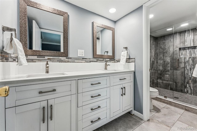 full bathroom with double vanity, a stall shower, toilet, and a sink