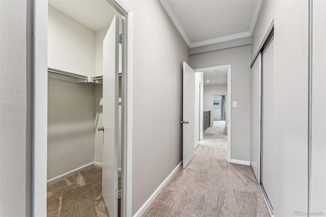 hallway featuring carpet flooring, crown molding, and baseboards