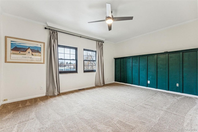 spare room featuring visible vents, carpet floors, ceiling fan, and crown molding