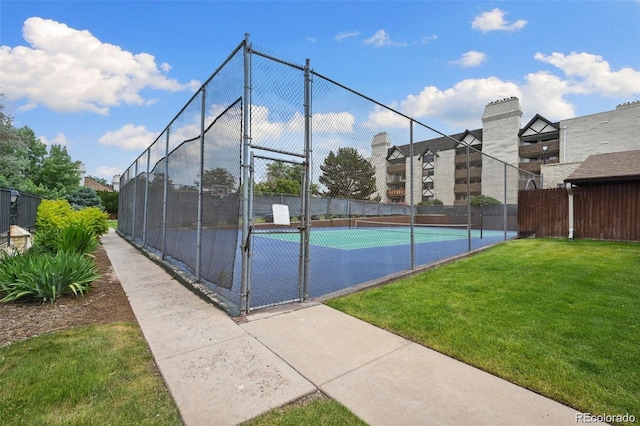 view of sport court featuring a gate, fence, and a lawn