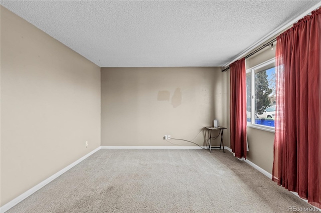 spare room featuring carpet floors and a textured ceiling