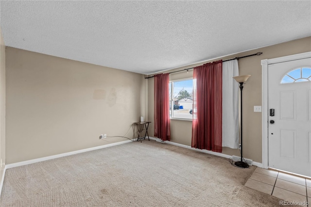 carpeted entryway with a textured ceiling