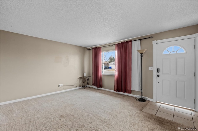 foyer with light colored carpet and a textured ceiling