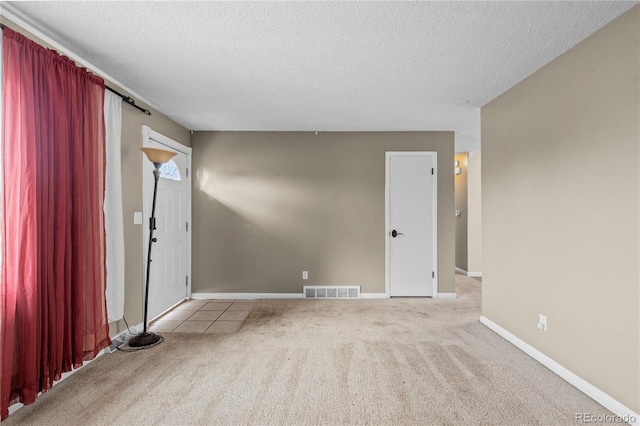 carpeted spare room featuring a textured ceiling