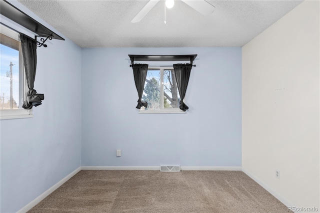 empty room featuring ceiling fan, a textured ceiling, and carpet flooring