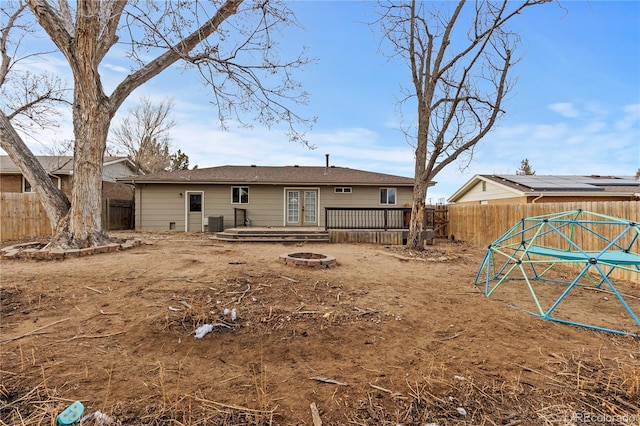 back of house featuring central AC unit and an outdoor fire pit