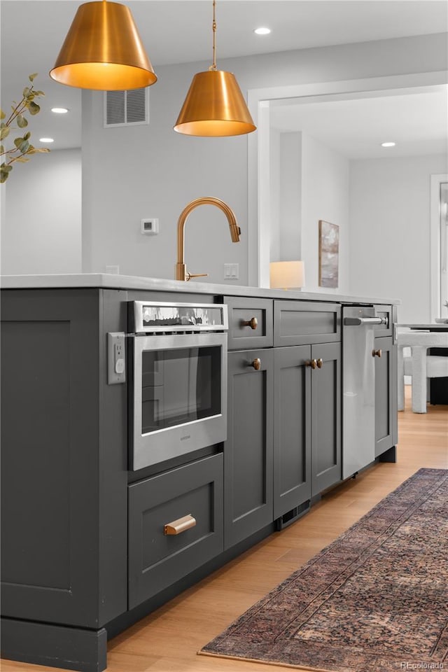 3256 S Corona, Englewood, CO 80113 - kitchen featuring stainless steel oven, gray cabinetry, light wood-style floors, decorative light fixtures, and recessed lighting