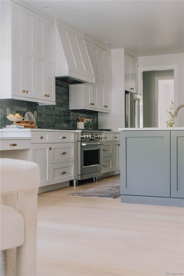 3256 S Corona, Englewood, CO 80113 - kitchen featuring custom exhaust hood, high end refrigerator, light wood finished floors, decorative backsplash, and wall oven