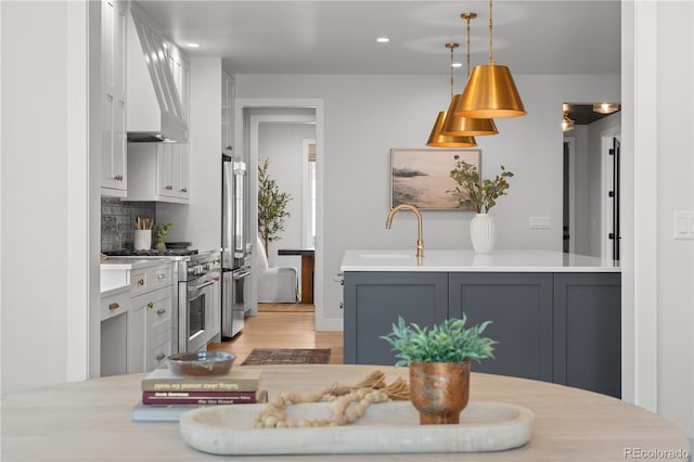 3256 S Corona, Englewood, CO 80113 - kitchen featuring premium appliances, custom exhaust hood, a sink, light countertops, and recessed lighting