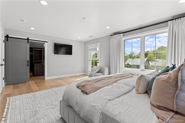 3256 S Corona, Englewood, CO 80113 - bedroom featuring a barn door, light wood finished floors, baseboards, recessed lighting, and access to exterior