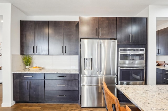 13960 Box Turtle Loop, Parker, CO 80134 - kitchen with tasteful backsplash, dark brown cabinetry, stainless steel appliances, and dark wood-type flooring