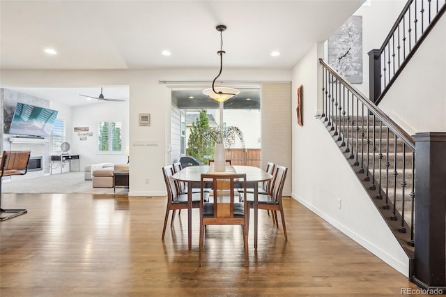 13960 Box Turtle Loop, Parker, CO 80134 - dining room featuring stairs, baseboards, a glass covered fireplace, and wood finished floors