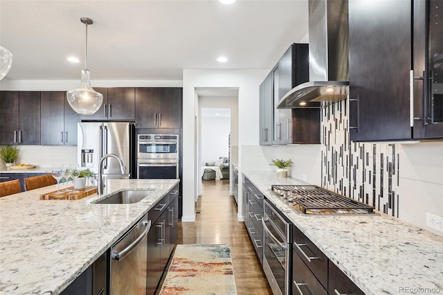 13960 Box Turtle Loop, Parker, CO 80134 - kitchen featuring wall chimney exhaust hood, light stone counters, a sink, appliances with stainless steel finishes, and backsplash