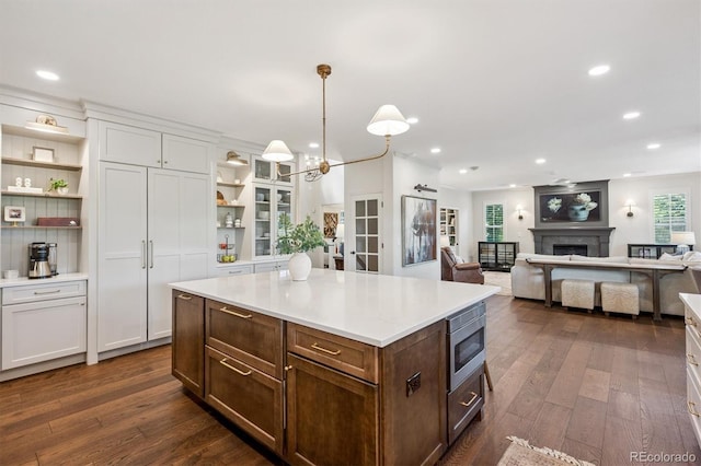 10660 Weathersfield Ct, Highlands Ranch, CO 80129 - kitchen with open shelves, stainless steel microwave, dark wood-style flooring, white cabinetry, and recessed lighting
