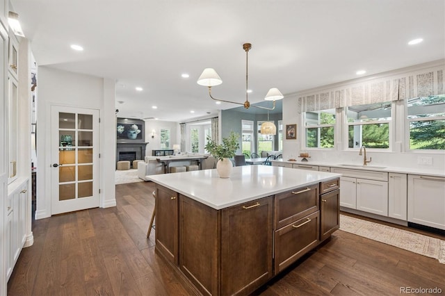 10660 Weathersfield Ct, Highlands Ranch, CO 80129 - kitchen with dark wood finished floors, light countertops, white cabinetry, pendant lighting, and recessed lighting
