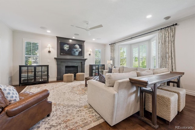 10660 Weathersfield Ct, Highlands Ranch, CO 80129 - living room featuring ceiling fan, wood finished floors, ornamental molding, a glass covered fireplace, and recessed lighting