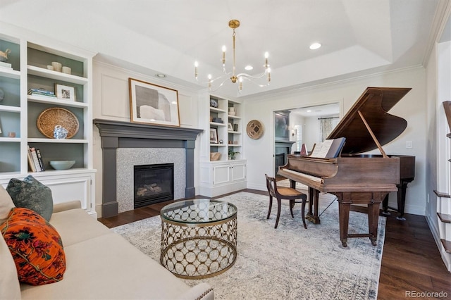 10660 Weathersfield Ct, Highlands Ranch, CO 80129 - living area with a fireplace, wood finished floors, a chandelier, built in shelves, and crown molding