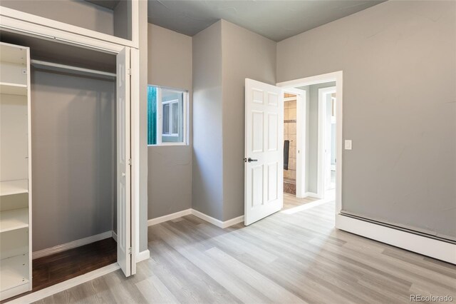 4595 S Lincoln St, Englewood, CO 80113 - unfurnished bedroom featuring a closet, light wood-style flooring, a baseboard heating unit, and baseboards