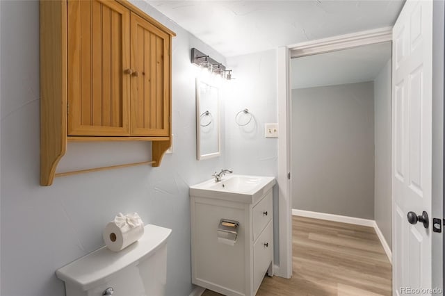 4595 S Lincoln St, Englewood, CO 80113 - half bathroom featuring toilet, vanity, wood finished floors, and baseboards
