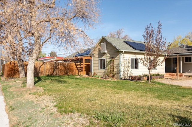 4595 S Lincoln St, Englewood, CO 80113 - view of side of property with roof with shingles, fence, a lawn, and roof mounted solar panels