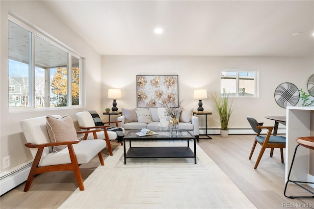 living room featuring light wood-type flooring and a baseboard heating unit