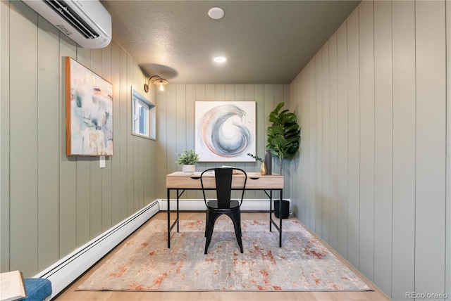 office featuring a baseboard heating unit, an AC wall unit, hardwood / wood-style floors, a textured ceiling, and wooden walls