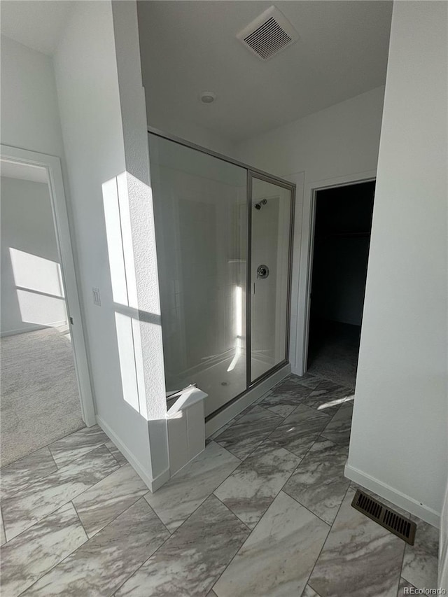 bathroom featuring a shower with door