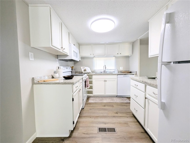 2032 Tulane St, Denver, CO 80260 - kitchen featuring white appliances, light wood-style floors, white cabinets, a textured ceiling, and light stone countertops
