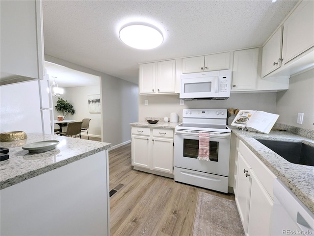 2032 Tulane St, Denver, CO 80260 - kitchen featuring white appliances, white cabinets, light wood-style flooring, light stone countertops, and a textured ceiling