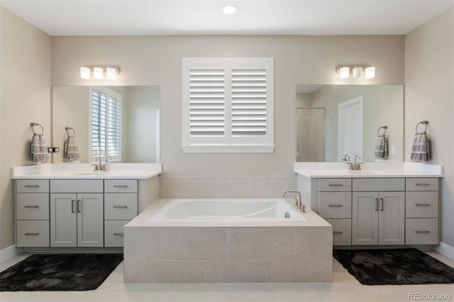 bathroom featuring vanity and independent shower and bath