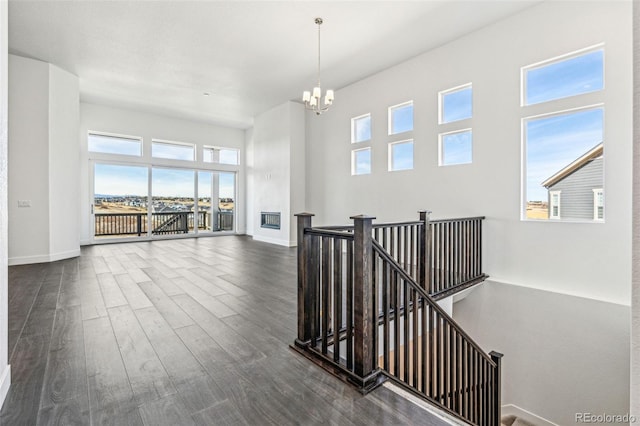 interior space featuring baseboards, a notable chandelier, and wood finished floors