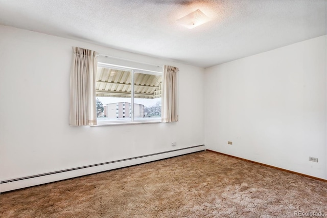 spare room with a baseboard heating unit, a textured ceiling, and carpet floors