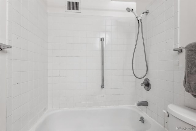 bathroom with toilet and tiled shower / bath combo