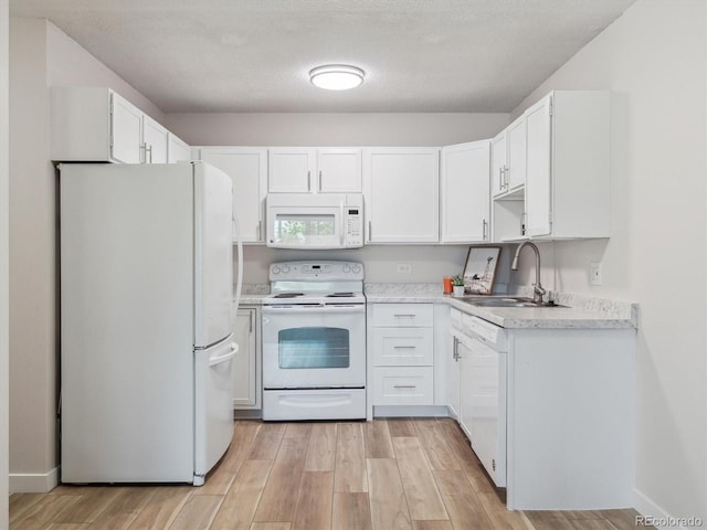 635 S Alton Way Unit 1C, Denver, CO 80247 - kitchen featuring white appliances, a sink, light wood-type flooring, white cabinetry, and light countertops