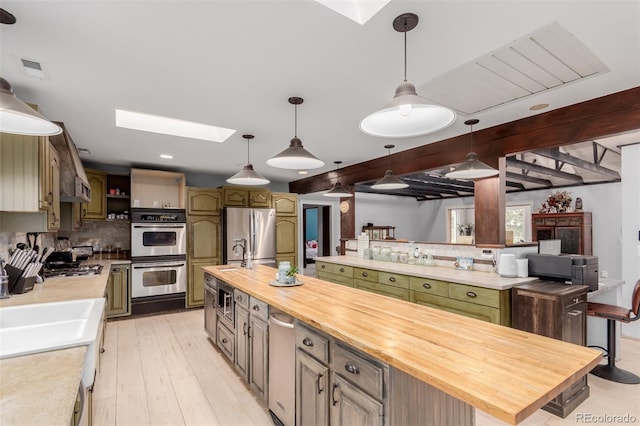 1341 Tomichi Dr, Franktown, CO 80116 - kitchen featuring a skylight, stainless steel appliances, a large island, wood counters, and tasteful backsplash
