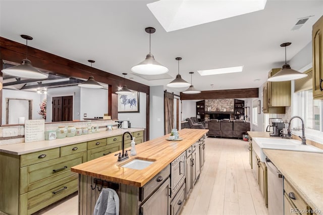 1341 Tomichi Dr, Franktown, CO 80116 - kitchen featuring a skylight, wooden counters, a center island with sink, a sink, and beamed ceiling