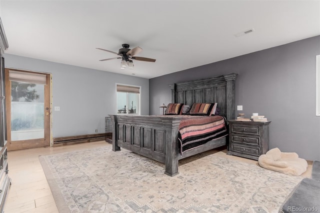 1341 Tomichi Dr, Franktown, CO 80116 - bedroom featuring multiple windows, baseboard heating, ceiling fan, and wood finished floors