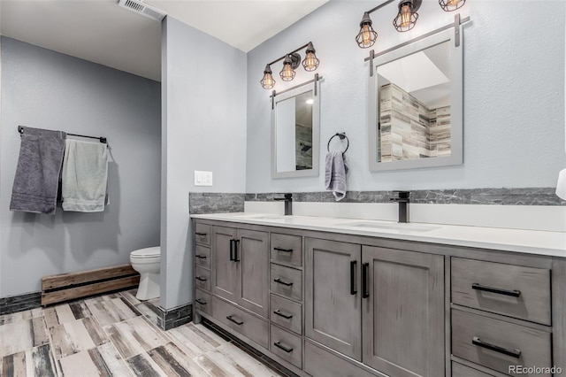 1341 Tomichi Dr, Franktown, CO 80116 - bathroom with double vanity, toilet, and wood finished floors