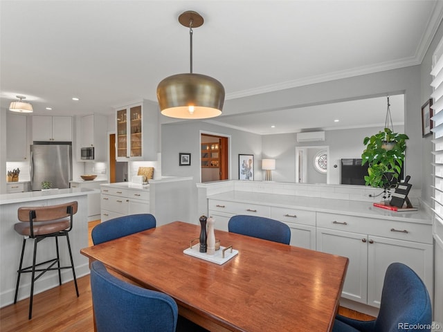 dining room with light wood-type flooring, recessed lighting, crown molding, and a wall mounted AC