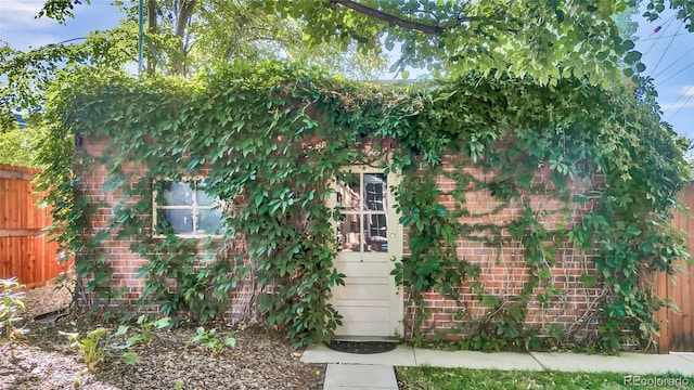 exterior space with fence and brick siding