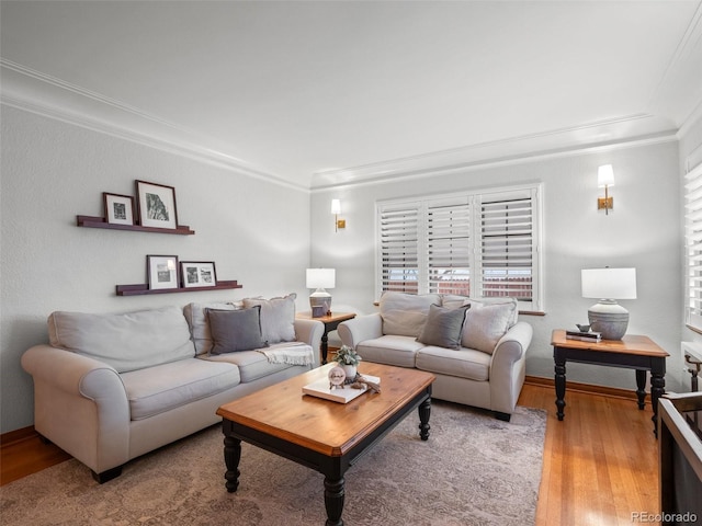 living area with baseboards, wood finished floors, and ornamental molding