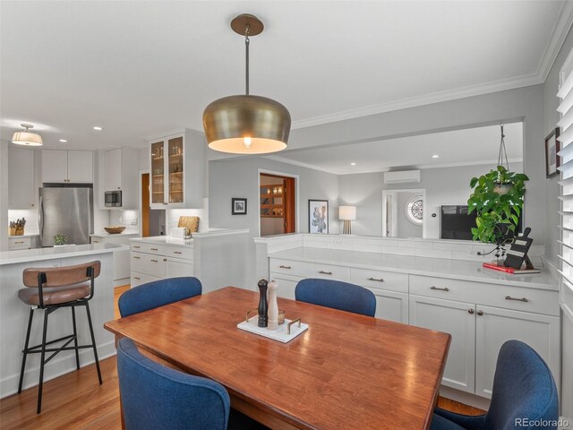 dining area with recessed lighting, crown molding, light wood finished floors, and a wall unit AC