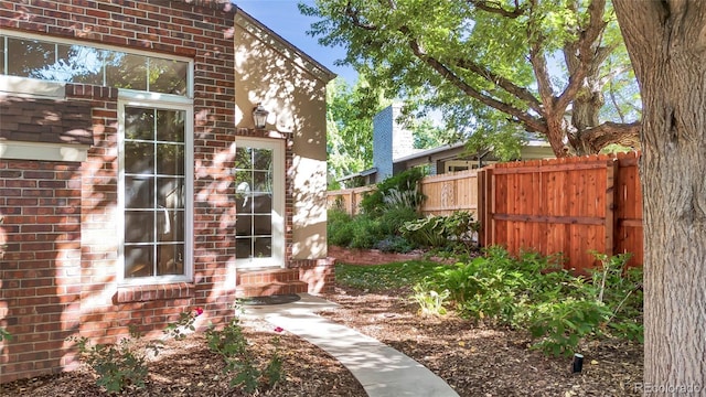 exterior space with fence and brick siding