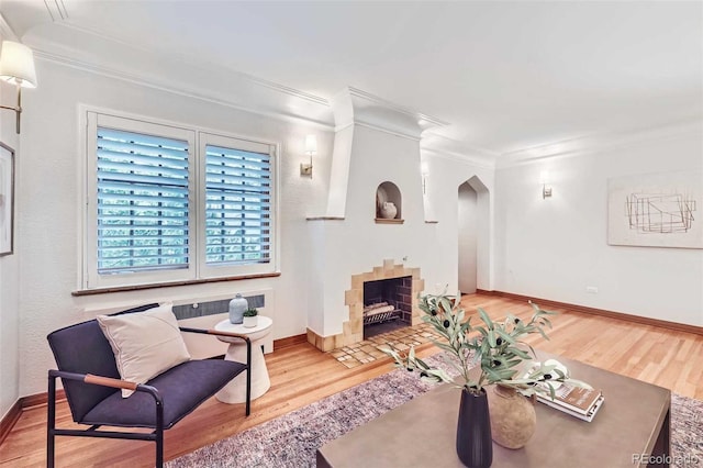 926 S Fillmore Way, Denver, CO 80209 - living area featuring arched walkways, crown molding, wood finished floors, baseboards, and a fireplace